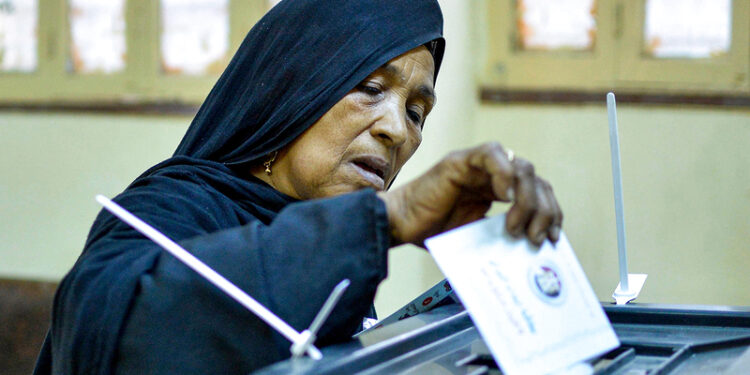 A woman voter casts her ballot at a polling station in Esna, about 55 kilometres south of Egypt's southern city of Luxor October 24, 2020, during the first stage of the lower house elections. - Polling stations opened in Egypt for parliamentary elections in which there was little doubt of a sweeping victory for supporters of hardline President Abdel Fattah al-Sisi. Some 63 million voters out of Egypt's more than 100 million people are eligible to elect 568 of the 596 lawmakers in the lower house, widely seen as a rubber-stamp body for executive policies. (Photo by - / AFP)