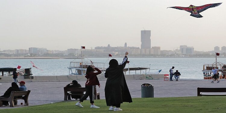 فتاة وامرأة يطيّران طائرة ورقية على الكورنيش في العاصمة القطرية الدوحة