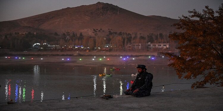 مقاتل من طالبان يصلي بجانب بحيرة قرغة على مشارف كابول / هيكتور ريتامال / وكالة الصحافة الفرنسية