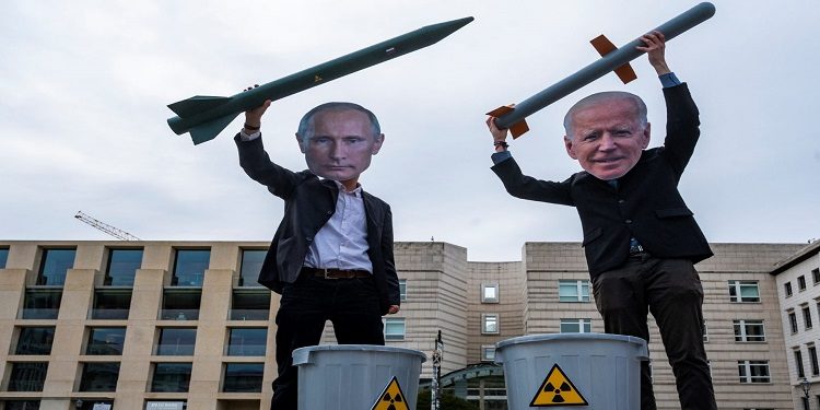 نشطاء سلام يرتدون أقنعة الرئيس الروسي فلاديمير بوتين (يسار) والرئيس الأمريكي جو بايدن يقفون بصواريخ نووية وهمية أمام السفارة الأمريكية في برلين، 29 يناير/كانون الثاني 2021
