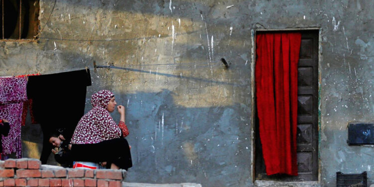 امرأة تنظر إلى جوار ابنتها في حي فقير بالقرب من وسط القاهرة، مصر (وكالات)