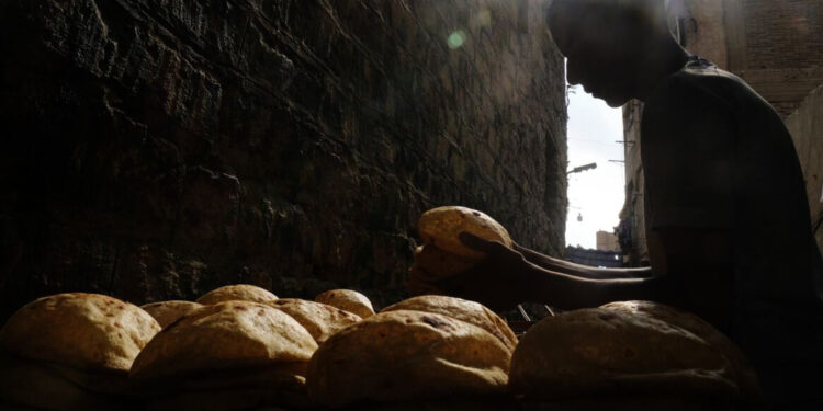 خباز يكدس أرغفة الخبز البلدي خارج مخبز، في القاهرة القديمة، 8 سبتمبر 2022. (وكالات)
