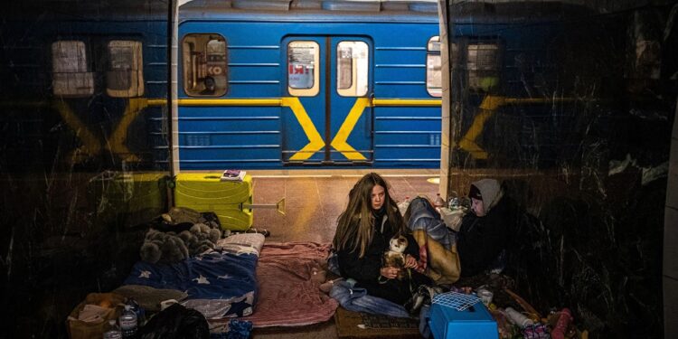 امرأة تعانق قطتها داخل محطة مترو تحت الأرض تستخدم مأوى من القصف في كييف في 8 مارس/آذار (وكالات)