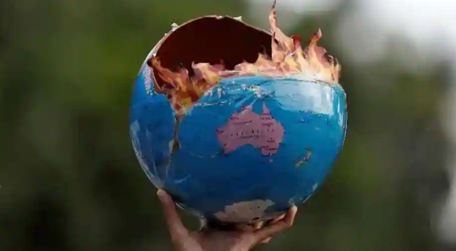مناهض للتغيرات المناخية يرفع نموذج مدمر للكرة الأرضية (الصورة: وكالات)