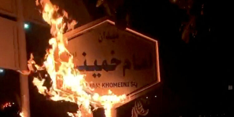 إحراق لافتة تحمل اسم الخميني خلال احتجاجات إيران (وكالات)