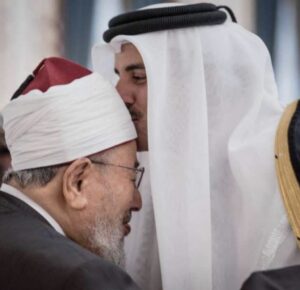 أمير قطر الشيخ تميم يقبل رأس الشيخ الراحل يوسف القرضاوي، أحد أبرز المؤيدين للإخوان، والذي تستضيفه قطر منذ سنوات طويلة. (وكالات)