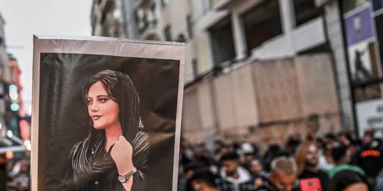متظاهر يحمل صورة مهسا أميني خلال مظاهرة لدعمها في تركيا، وهي شابة إيرانية توفيت بعد اعتقالها في طهران من قبل شرطة الأخلاق في إيران، 20 سبتمبر 2022 (وكالات)