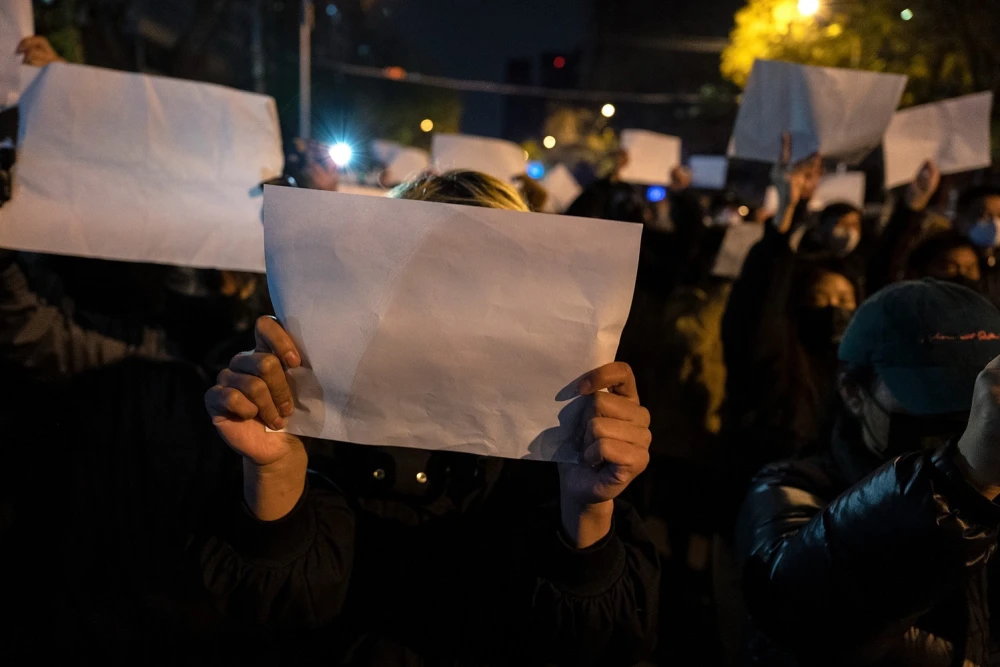 المتظاهرون يحملون قطعًا بيضاء من الورق ضد الرقابة أثناء مسيرة خلال احتجاج على إجراءات الصين الصارمة لمنع انتشار فيروس كورونا الجديد في بكين، 27 نوفمبر/ تشرين الثاني. (الصورة: وكالات)