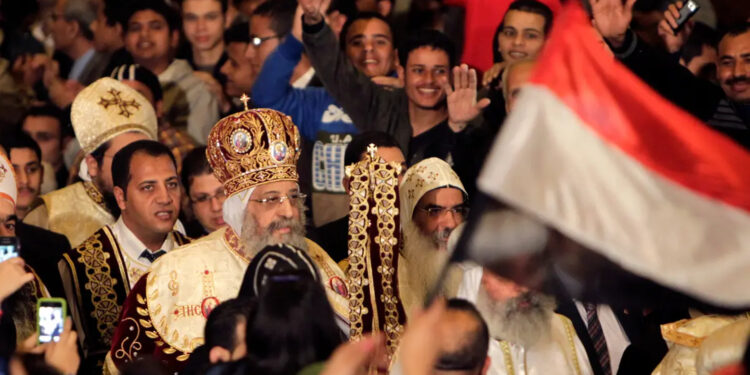 مسيحيون مصريون يلوحون للبابا تواضروس الثاني أثناء حضورهم قداس عشية عيد الميلاد في القاهرة ، 6 يناير 2014 (وكالات)