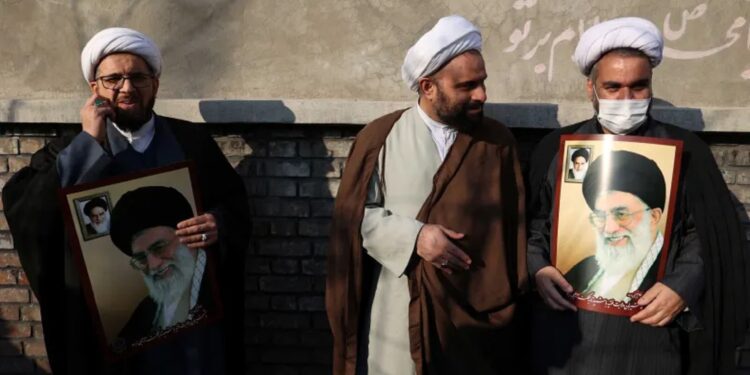 رجال دين إيرانيون يحملون صور المرشد الأعلى آية الله علي خامنئي في طهران، يناير/ كانون الثاني 2023 (وكالات)