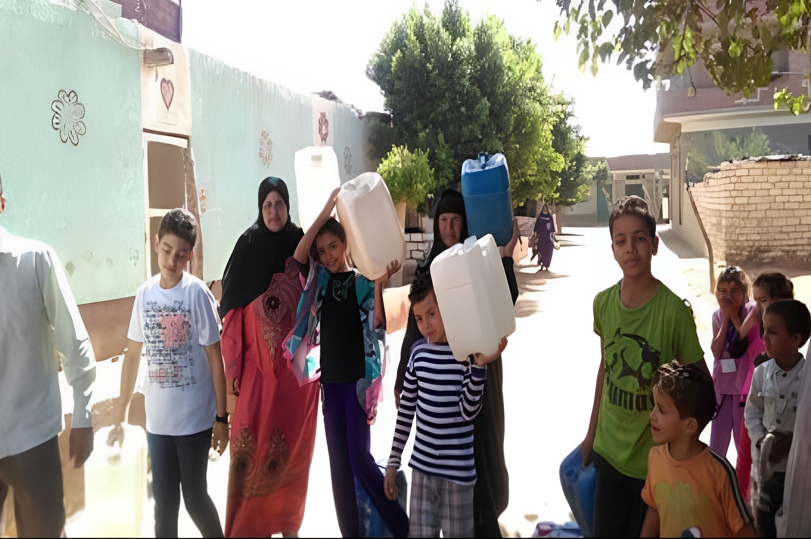 نساء وأطفال يحملون جالونات مياه شرب في إحدى القرى المصرية (وكالات)