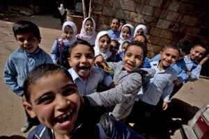 تجمع تلاميذ مصريون لالتقاط صورة لمصور بالقرب من مدرسة في 4 مارس 2013 في القاهرة (وكالات)