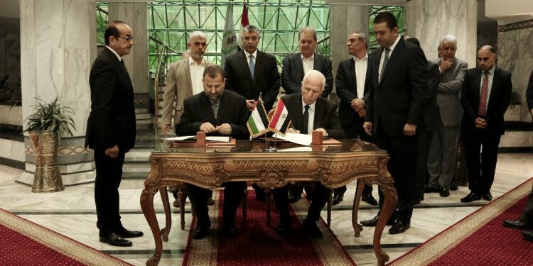 القيادي في فتح عزام الأحمد (يمين)، والقيادي في حماس صالح العاروري (يسار) يوقعان اتفاقية مصالحة برعاية مصرية عام 2017