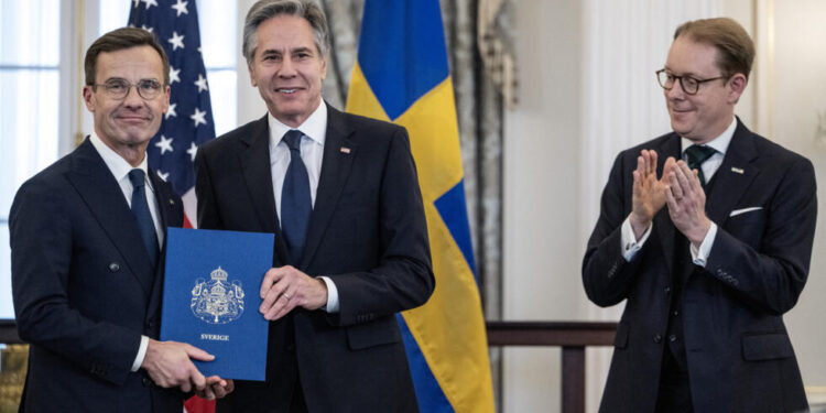 رئيس الحكومة السويدية أولف كريسترسون "يسار" يتسلم من وزير الخارجية الأمريكي أنتوني بلينكن في واشنطن الخميس الوثيقة الرسمية لانضمام السويد للناتو (وكالات)